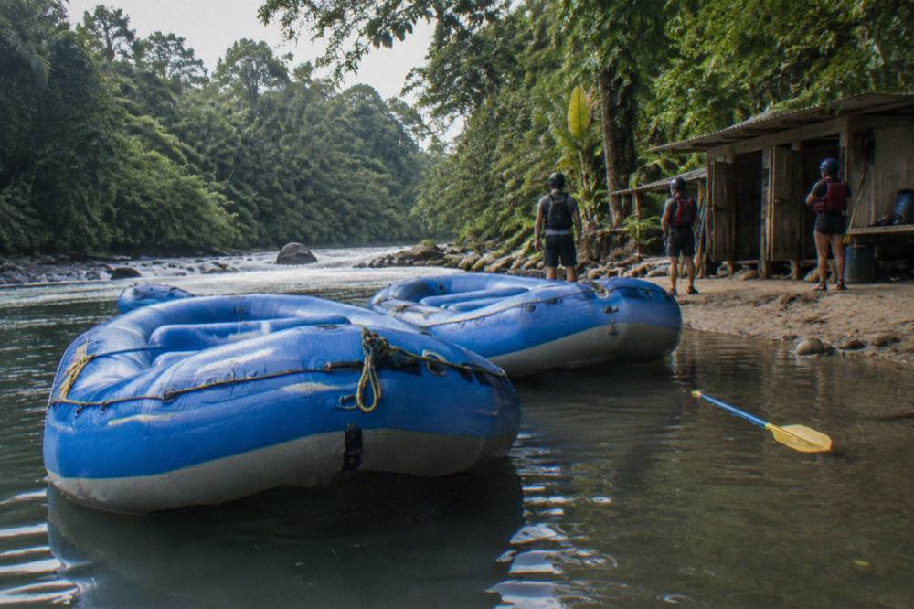 Two rafts side by side in a calm pool between jungle rapids