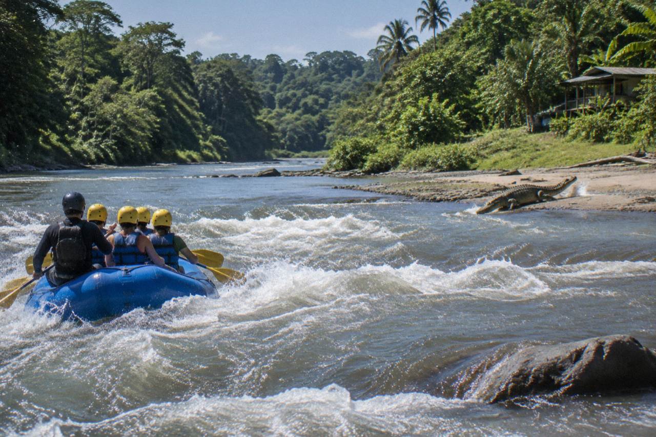 A raft cutting through a jungle rapid on a wide tropical river with dense green forest on both banks
