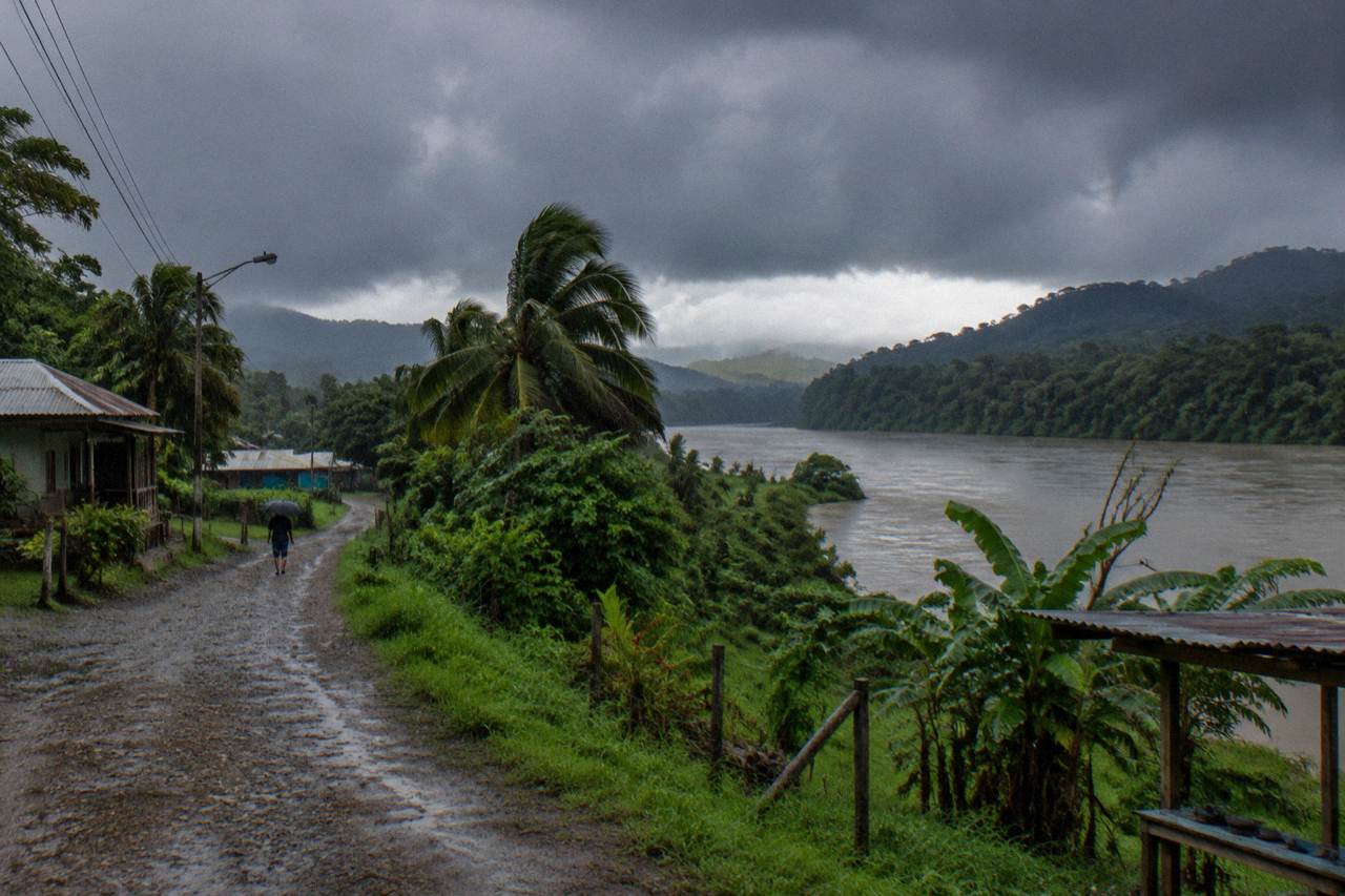 Rain clouds over lush green jungle hills above a wide tropical river