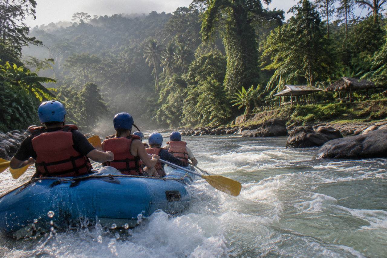 A raft cutting through a green jungle rapid on the Sarapiqui River