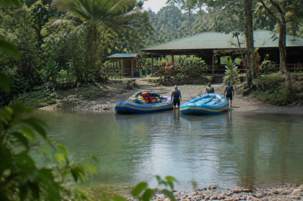 Two rafts lined up on a calm jungle river between green banks