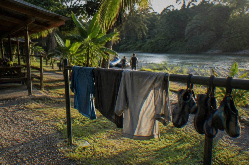Quick-dry shirts and water shoes drying on a railing after a rafting trip